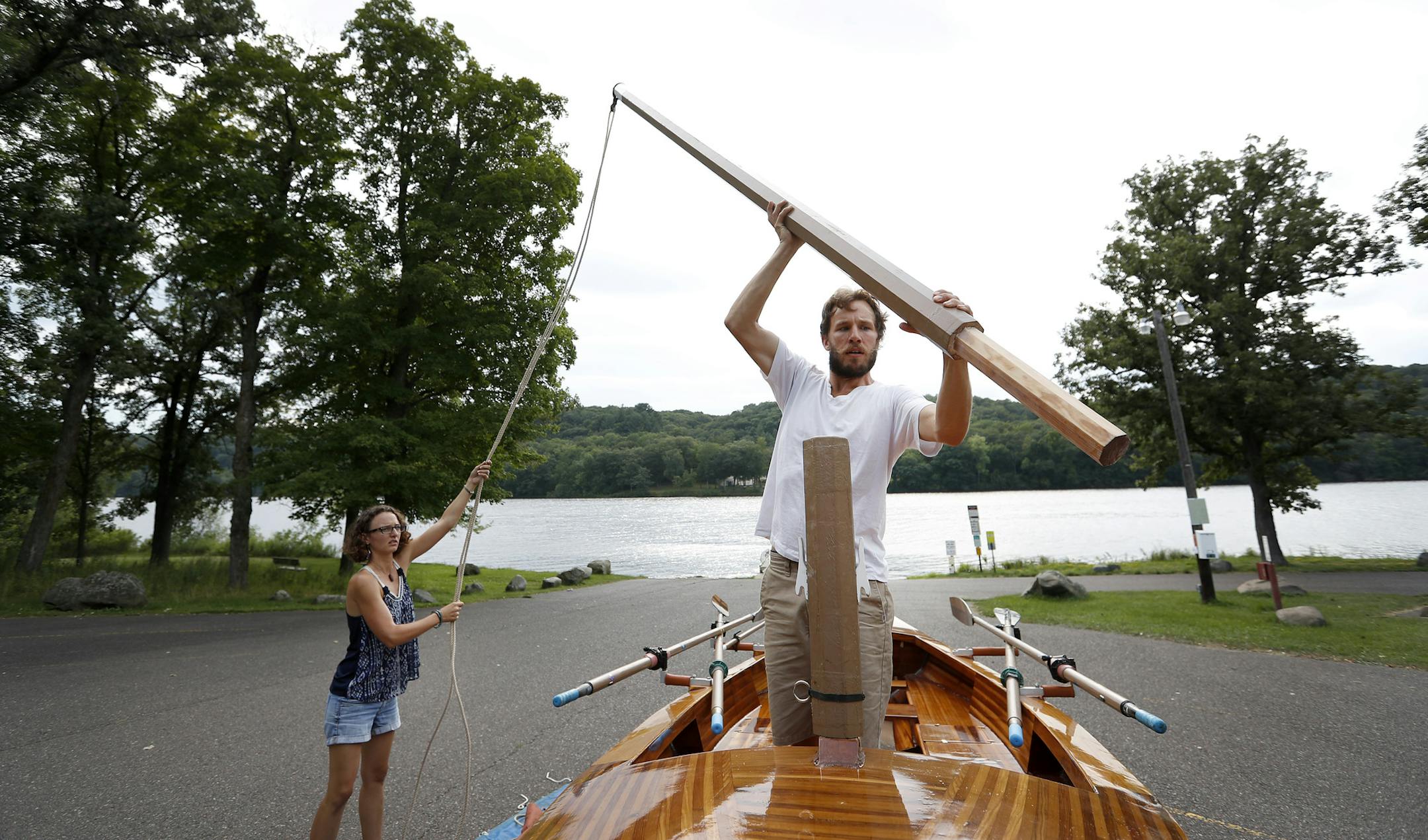 Danielle Kreusch and Kyle Hawkins placed the mast on the Solvi. The couple built the boat themselves which took an estimated 1,600 hours to build. ] CARLOS GONZALEZ cgonzalez@startribune.com - August 10, 2016, St. Croix Falls, WI, Young couple builds its own boat in preparation for sailing down the Mississippi. Kyle Hawkins and Danielle Kreusch