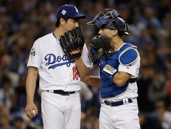 Dodgers pitcher Kenta Maeda talks to catcher Austin Barnes during the seventh inning of Game 6 of the World Series against the Houston Astros