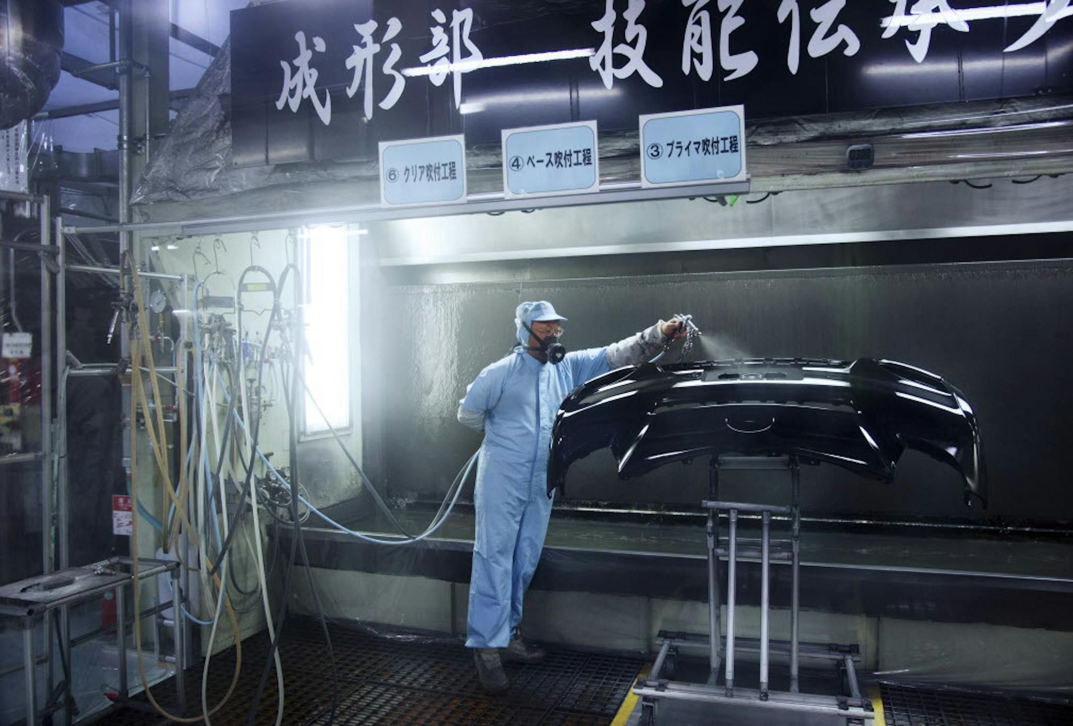 A worker paints a bumper at Toyota's Takaoka Factory in Toyota, Japan, July 16, 2015. Burdened by weaker consumer spending and exports, Japanís economy contracted in the second quarter, government data showed on Monday, the first such setback since a short but painful recession last year. (Ko Sasaki/The New York Times)