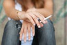 iStockphoto.com Teenage hands holding cigarette outdoor.