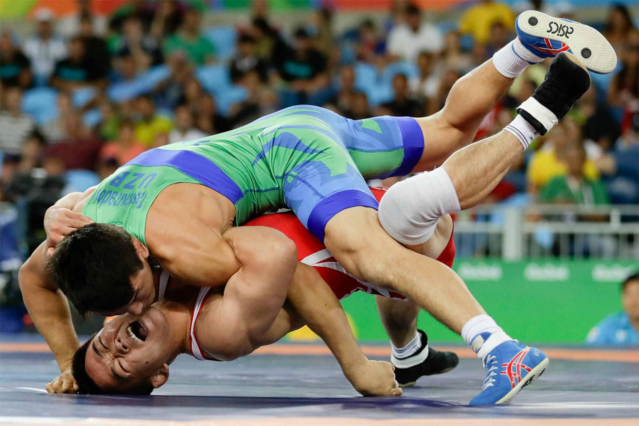 North Korea's Yun Won Chol competes against Uzbekistan's Elmurat Tasmuradov during the men's wrestling Greco-Roman 59-kg competition at the 2016 Summer Olympics in Rio de Janeiro, Brazil, Sunday, Aug. 14, 2016.