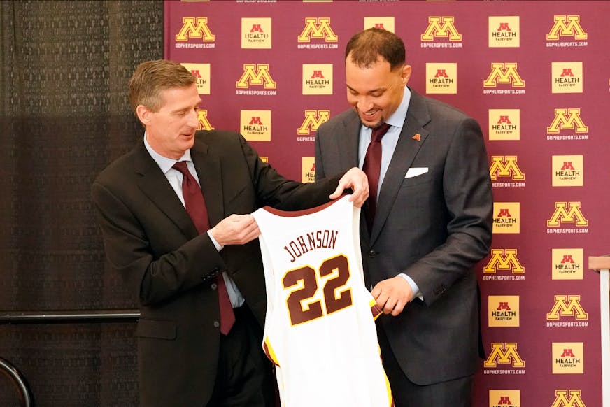 New University of Minnesota mens' head basketball coach Ben Johnson, right, receives his own number from athletic director Mark Coyle following a press conference to introduce Johnson, Tuesday, March 23, 2021, in Minneapolis. Johnson replaces Richard Pitino, who was fired after eight seasons and took the job at New Mexico. (AP Photo/Jim Mone)