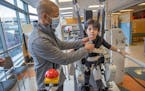 Tony Lee was by his son, Navon, as he took on the Lokomat machine during a physical therapy visit at Gillette Hospital, Monday, February 22, 2021 in S