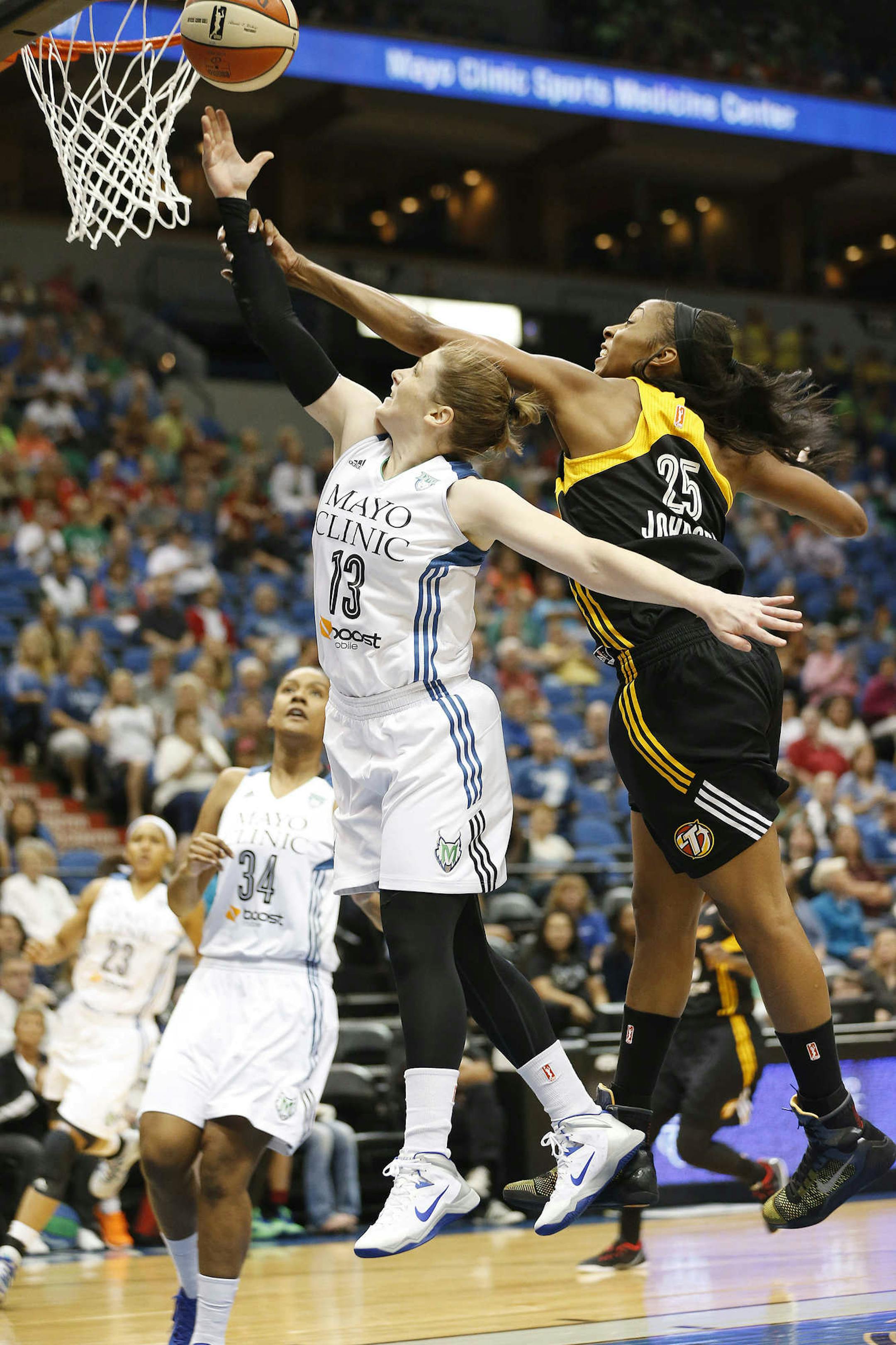 Minnesota Lynx guard Lindsay Whalen (13) is fouled by Tulsa Shock forward Glory Johnson (25) as she pushes up to shoot the ball in the first half of a WNBA basketball game, Wednesday, July 16, 2014, in Minneapolis. (AP Photo/Stacy Bengs)