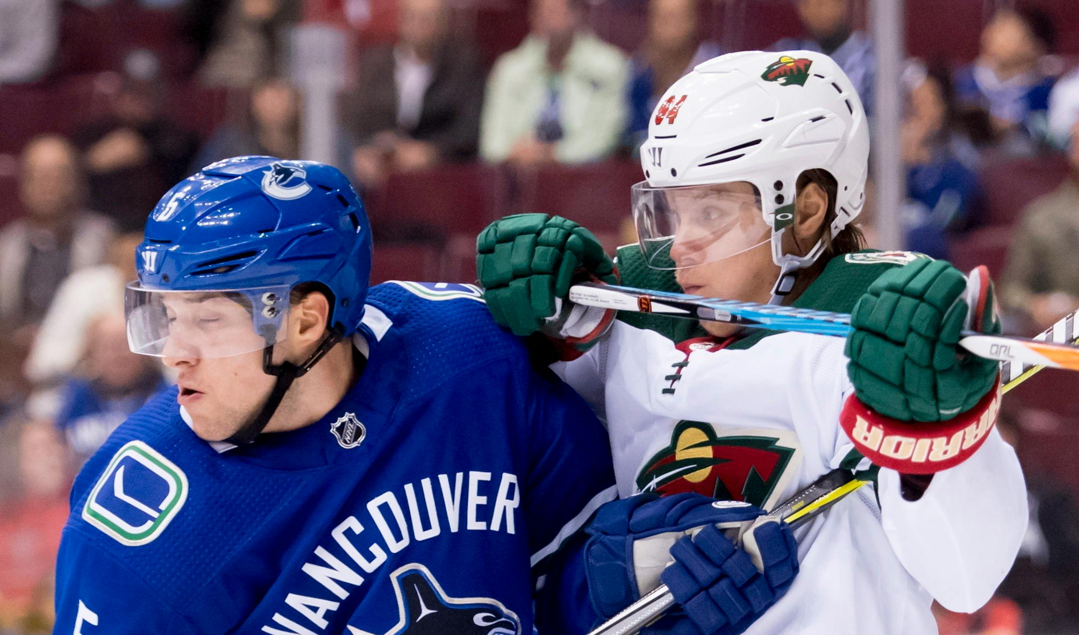 Wild right winger Mikael Granlund jostled for control of the puck with Canucks defenseman Derrick Pouliot in the first period of Vancouver's 5-2 victory on Monday night.