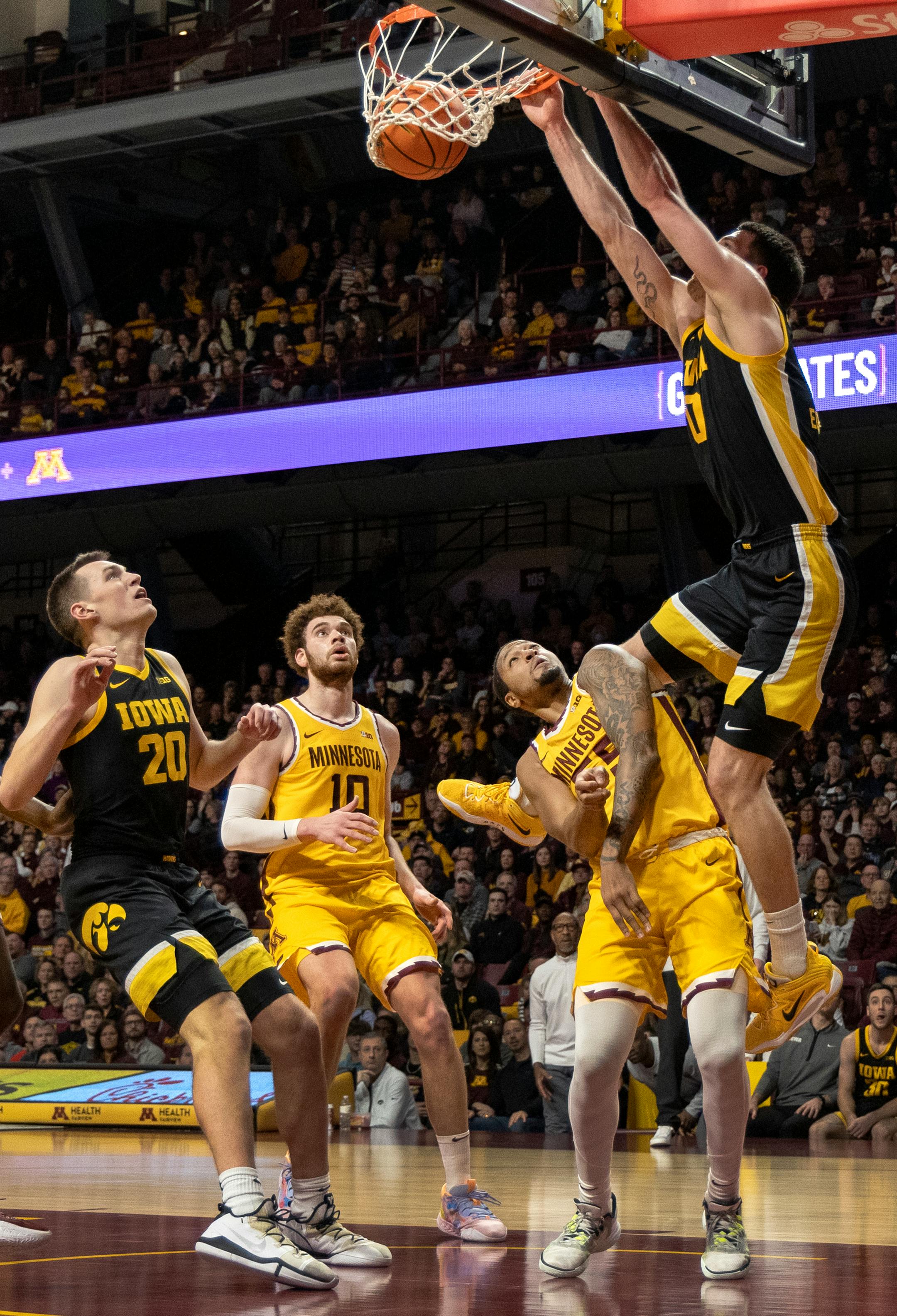 Filip Rebraca (0) of the Iowa dunks the ball while defended by Ta'Lon Cooper (55) of the Minnesota Gophers in the second half.