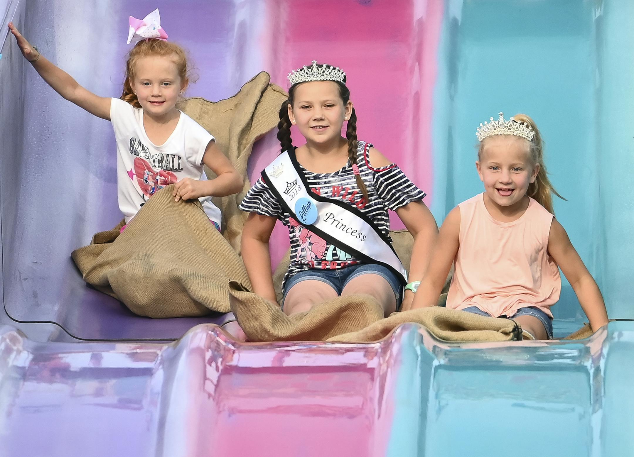 From left, Stella Manuel, 5, Lillian Lydeen, 9, and Lainey Manuel, 7, all from Watkins, rode a potato sack down a slide Thursday night at the Meeker County Fair. Lillian and Lainey were both Little Miss Watkins Princesses, but Stella said that that the "rides!" are what keep her coming back to the fair. ] Aaron Lavinsky ¥ aaron.lavinsky@startribune.com In just a couple of weeks, the annual get together that is the Minnesota State Fair will be underway. But there's a different kind of fair b
