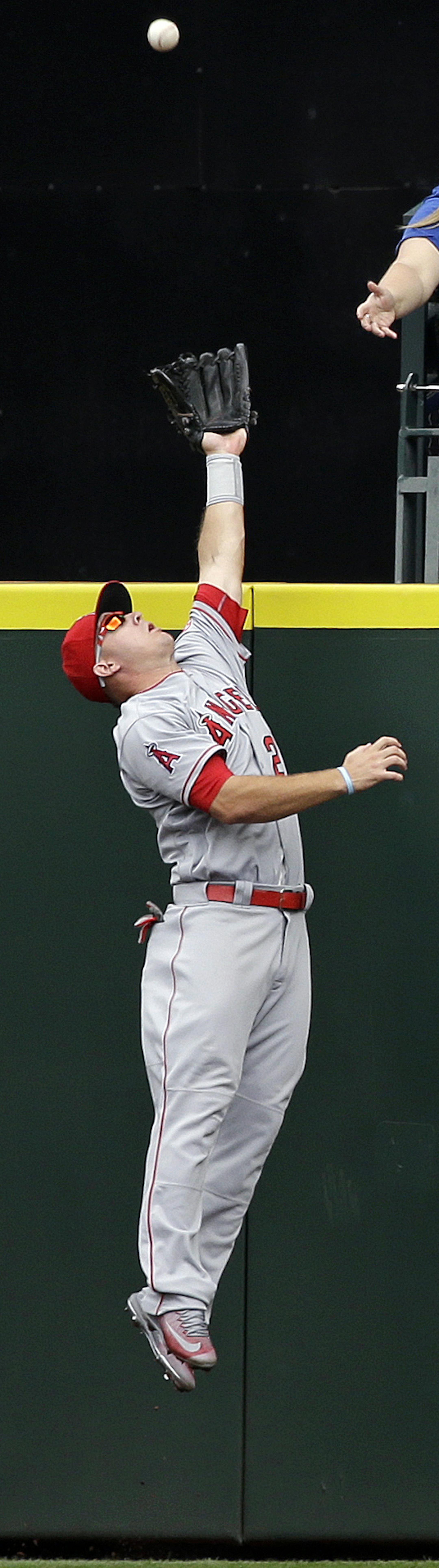 Los Angeles Angels center fielder Mike Trout leaps to snag a fly ball from Seattle Mariners' Leonys Martin at the wall in the fourth inning of a baseball game Sunday, Aug. 7, 2016, in Seattle. One run scored on the sacrifice fly. (AP Photo/Elaine Thompson)