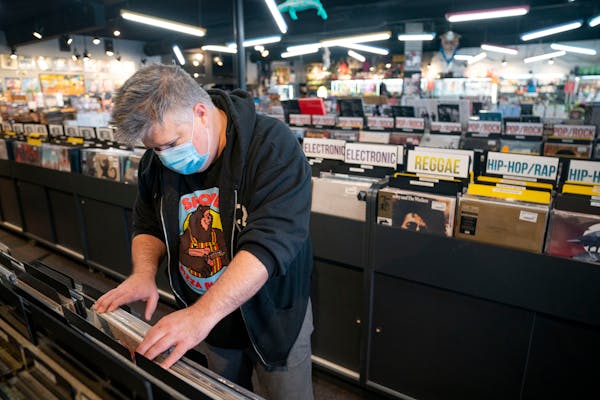 Adam Kooyer, a regular at Down in the Valley, peruses the store's used vinyl collection Thursday, Feb. 10, 2022 in Golden Valley, Minn.