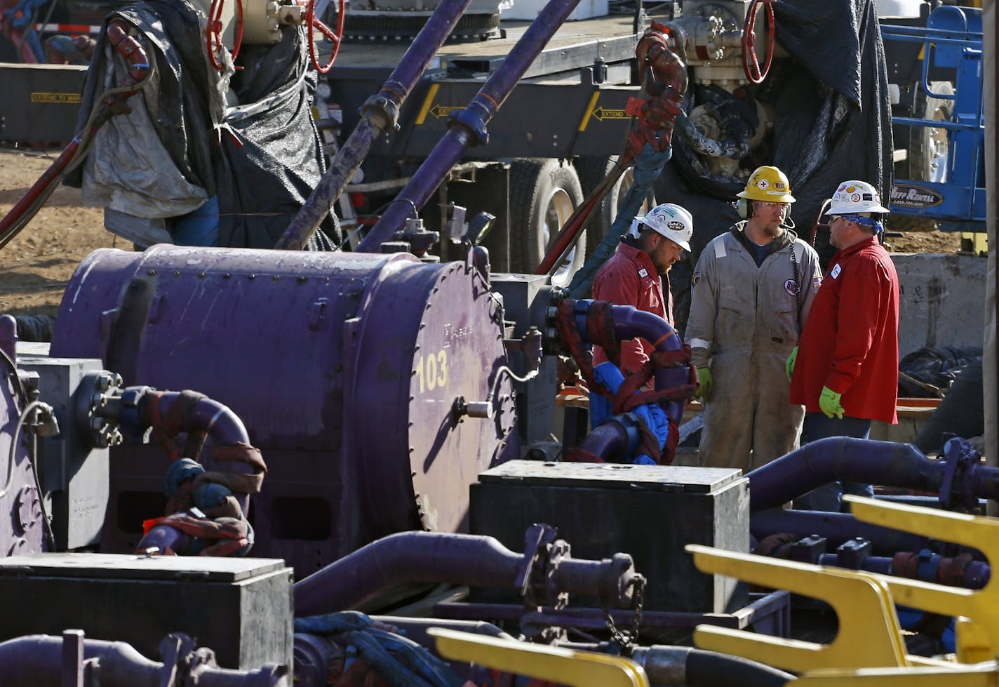 In this March 25, 2014 photo, workers talk during a hydraulic fracturing operation at an Encana Corp. well pad near Mead, Colo. Hydraulic fracturing, or &#x201c;fracking,&#x201d; can greatly increase the productivity of an oil or gas well by splitting open rock with water and/or sand pumped underground at high pressure. (AP Photo/Brennan Linsley) (AP Photo/Brennan Linsley)