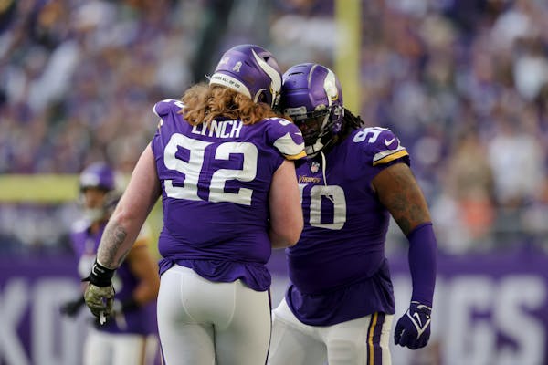 Minnesota Vikings defensive tackles Sheldon Richardson (90) and James Lynch (92) celebrate after a play during the second half of an NFL football game