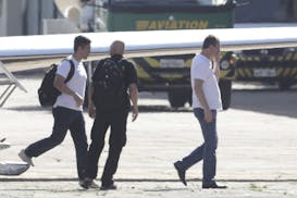 Joesley Batista, former chairman of JBS meatpacking giant, right, arrives at the airport during his transfer to a federal police jail after he turned 