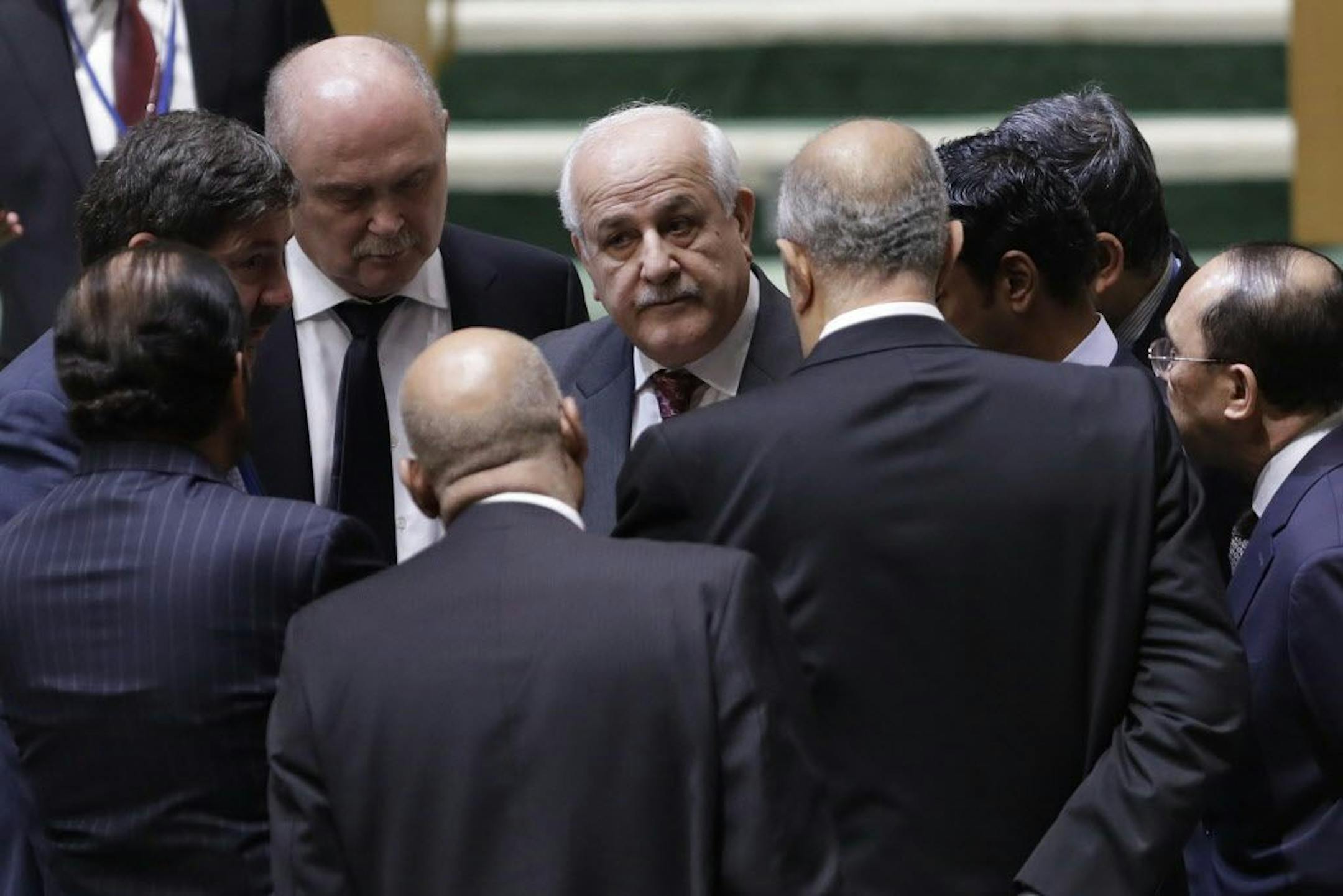 Palestinian Ambassador to the United Nations Riyad Mansour, center, talks with members of the General Assembly prior to a vote, Thursday, Dec. 21, 2017, at United Nations headquarters. President Donald Trump's threat to cut off U.S. funding to countries that oppose his decision to recognize Jerusalem as Israel's capital has raised the stakes in Thursday's U.N. vote and sparked criticism of his tactics, with one Muslim group calling it bullying or blackmail.