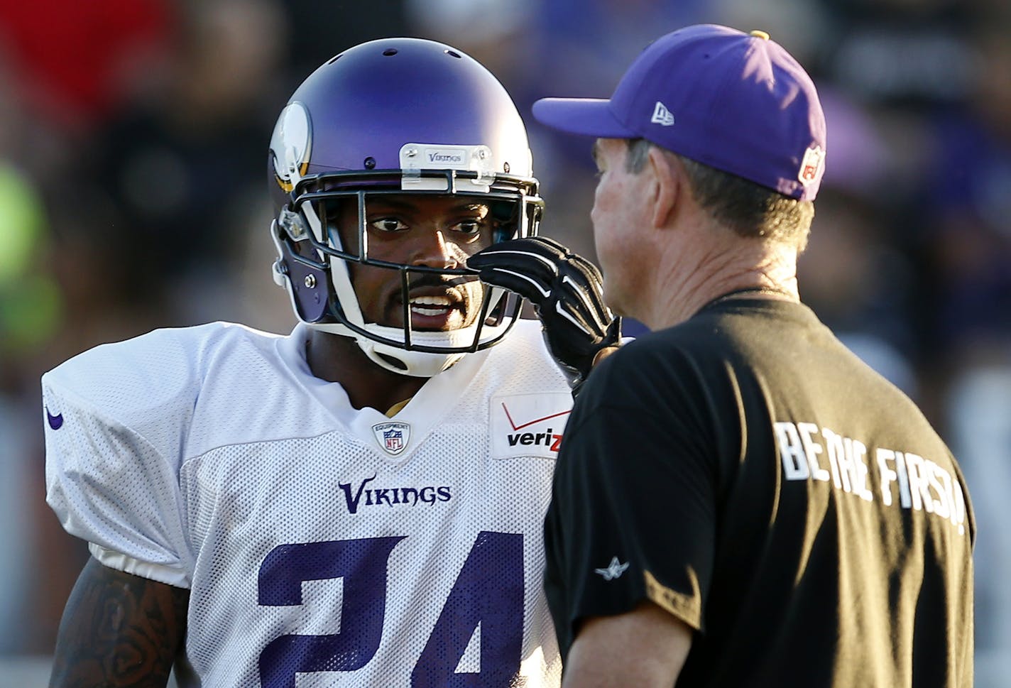 Minnesota Vikings head coach Mike Zimmer spoke with Captain Munnerlyn (24) during an evening practice in Mankato.