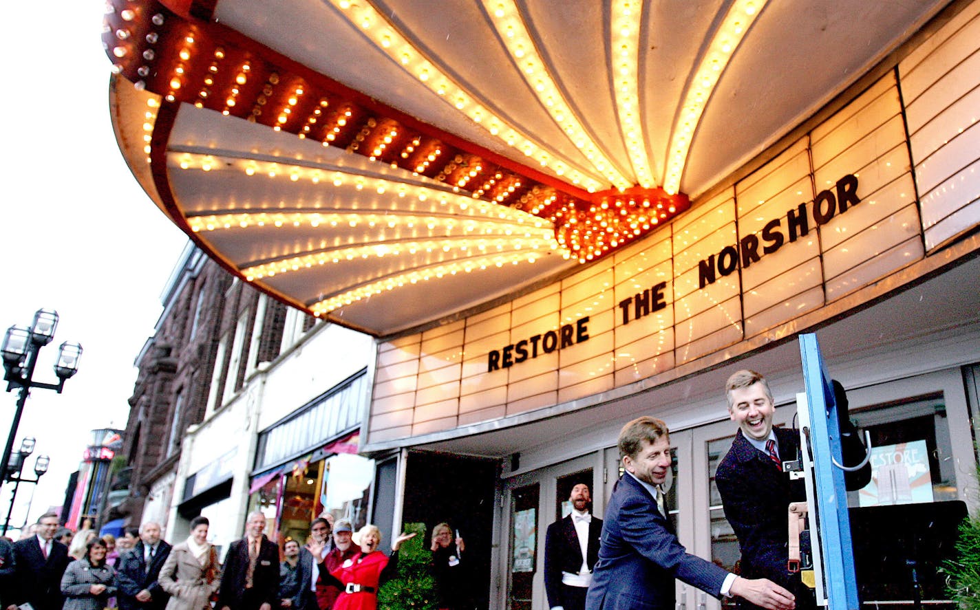 t10.29.2013 -- Steve Kuchera -- kucheraNORSHORE1030 -- Duluth Mayor Don Ness laughs after the NorShor Theatre&#x201a;&#xc4;&#xf4;s marquee lights come on before he and developer George Sherman flipped the switch that was to signal the marquee&#x201a;&#xc4;&#xf4;s lighting Tuesday. The lighting was part of an event celebrated the planned restoration of the building. Steve Kuchera / skuchera@duluthnews.com