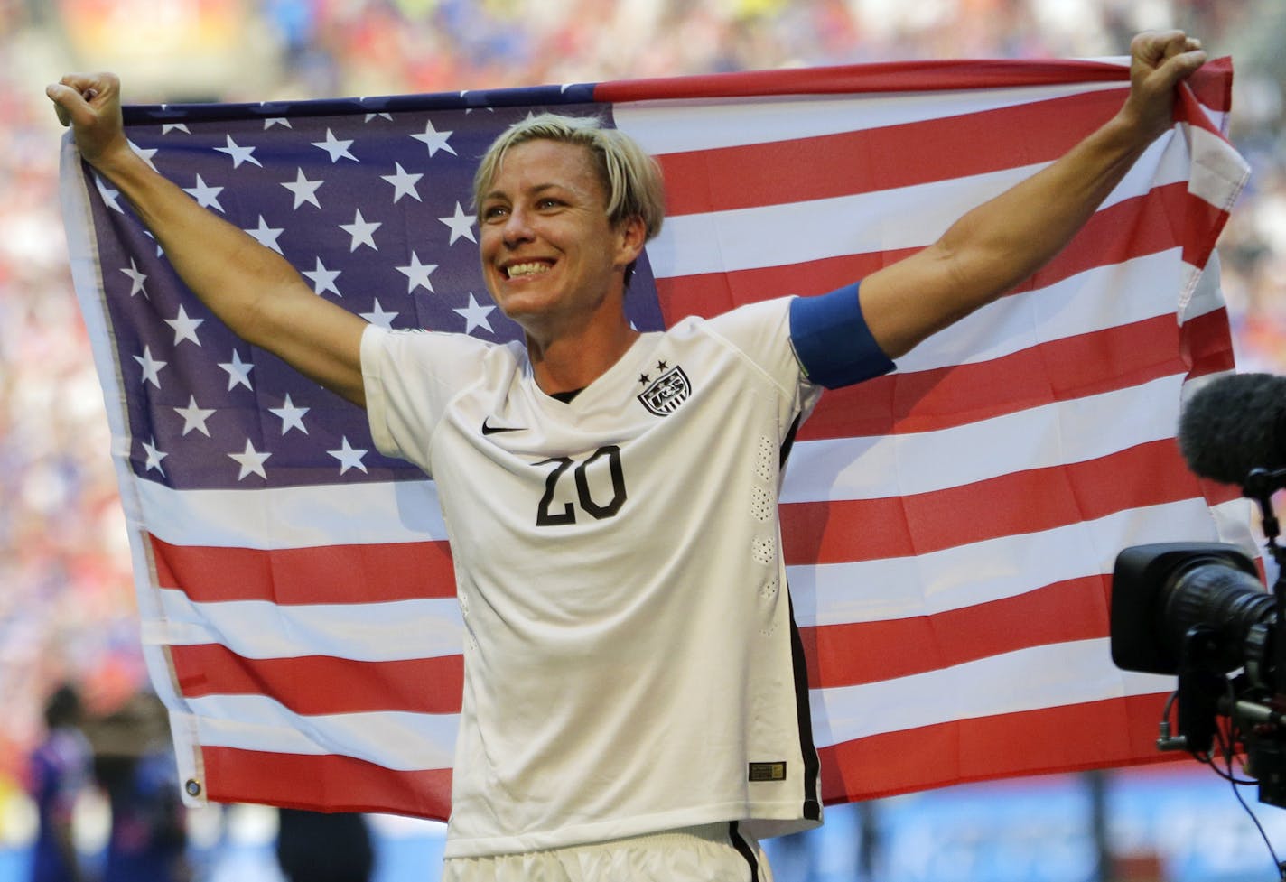 United States' Abby Wambach holds up the U.S. flag as she celebrates after the U.S. beat Japan 5-2 in the FIFA Women's World Cup soccer championship in Vancouver, British Columbia, Canada, Sunday, July 5, 2015. (AP Photo/Elaine Thompson)