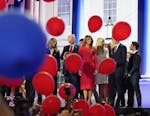Former President Donald Trump, the Republican presidential nominee, watches balloons fall as he stands on stage with Melania Trump and family on the f