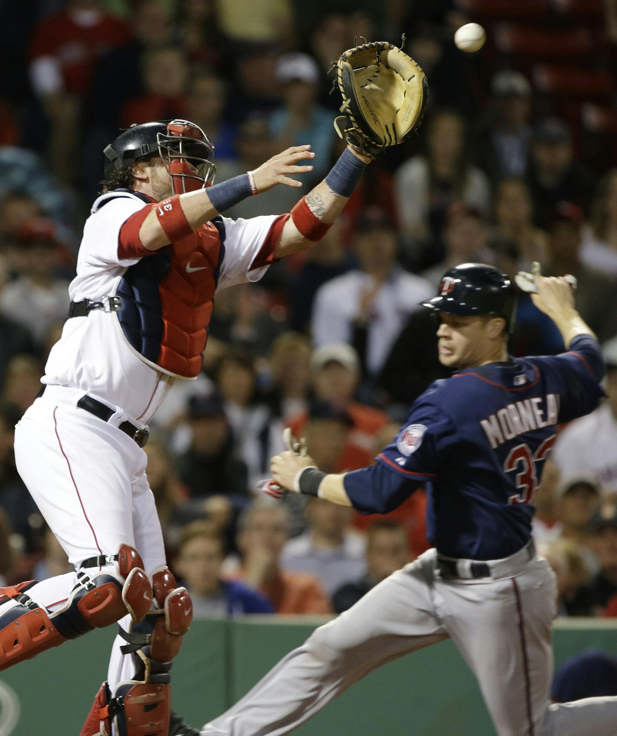 Boston Red Sox catcher Jarrod Saltalamacchia reaches for a high throw as Minnesota Twins' Justin Morneau slides in to score on a grounder by Ryan Doumit during the eighth inning of a baseball game at Fenway Park in Boston, Tuesday, May 7, 2013. (AP Photo/Elise Amendola)