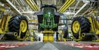FILE - In this April 9, 2019, wheels are attach as workers assemble a tractor at John Deere's Waterloo, Iowa assembly plant. Deere & Co. reports earni