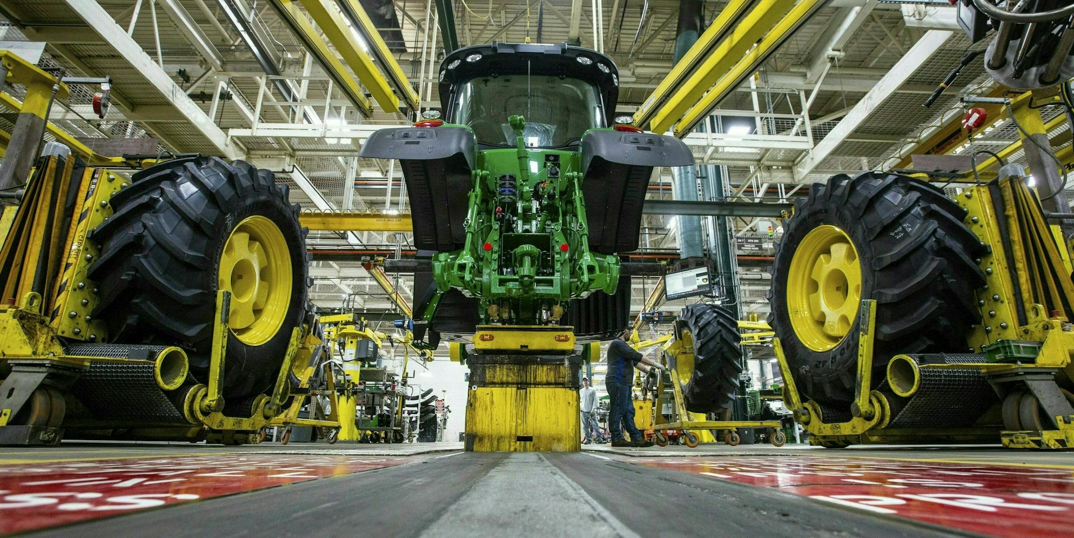 FILE - In this April 9, 2019, wheels are attach as workers assemble a tractor at John Deere's Waterloo, Iowa assembly plant. Deere & Co. reports earnings on Friday, May 17. (Zach Boyden-Holmes/Telegraph Herald via AP, File) ORG XMIT: IADUB301