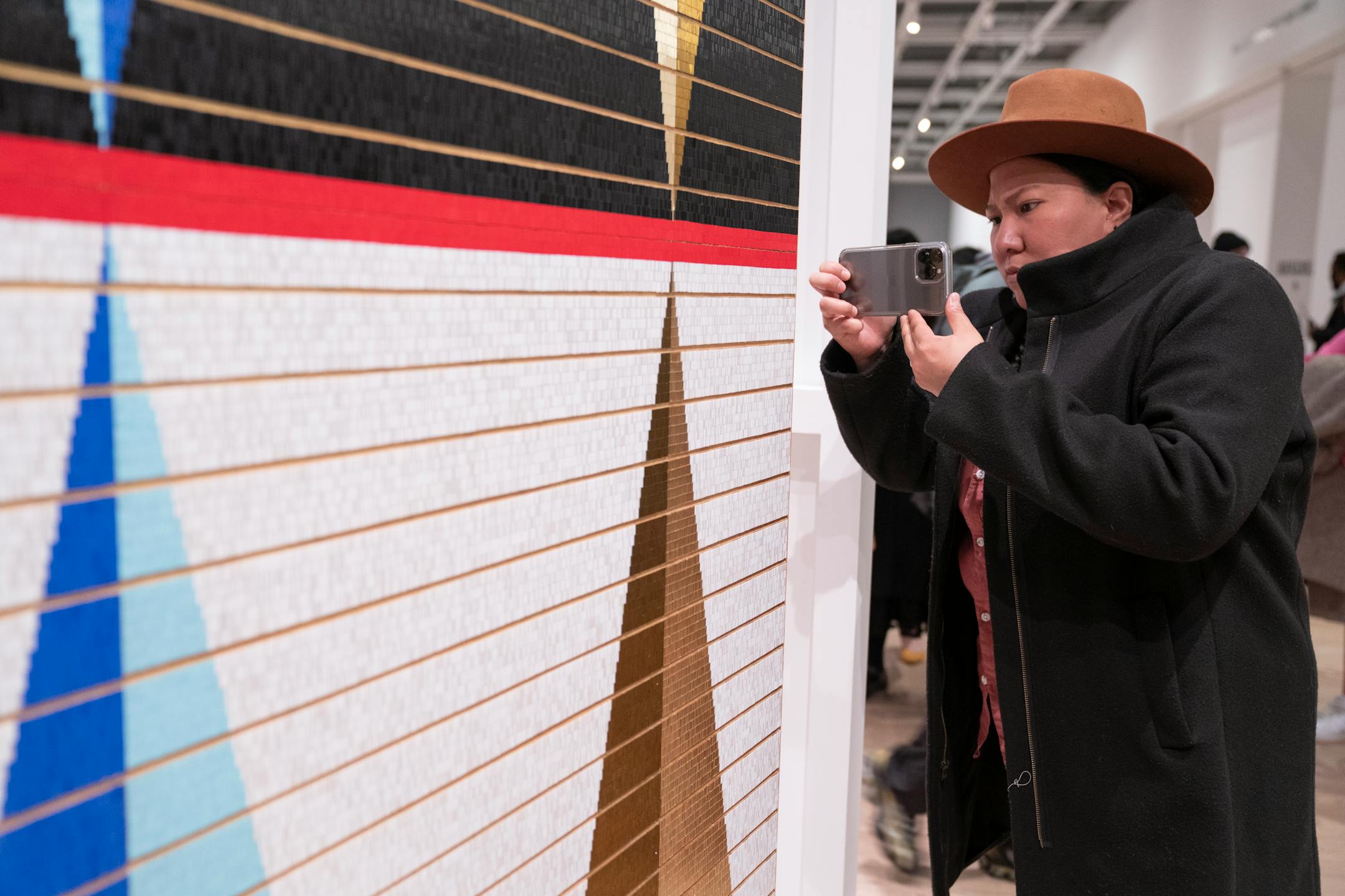 Razelle Benally takes a photo of Dyani White Hawk's work at the Whitney Museum of Art during its Biennial in New York, N.Y., on Wednesday, March 30, 2022. Barry Williams