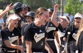 Mankato East outfielder Emily Hacker (1) is met by her teammates at home plate after hitting a home run against Chisago Lakes in the seventh inning of