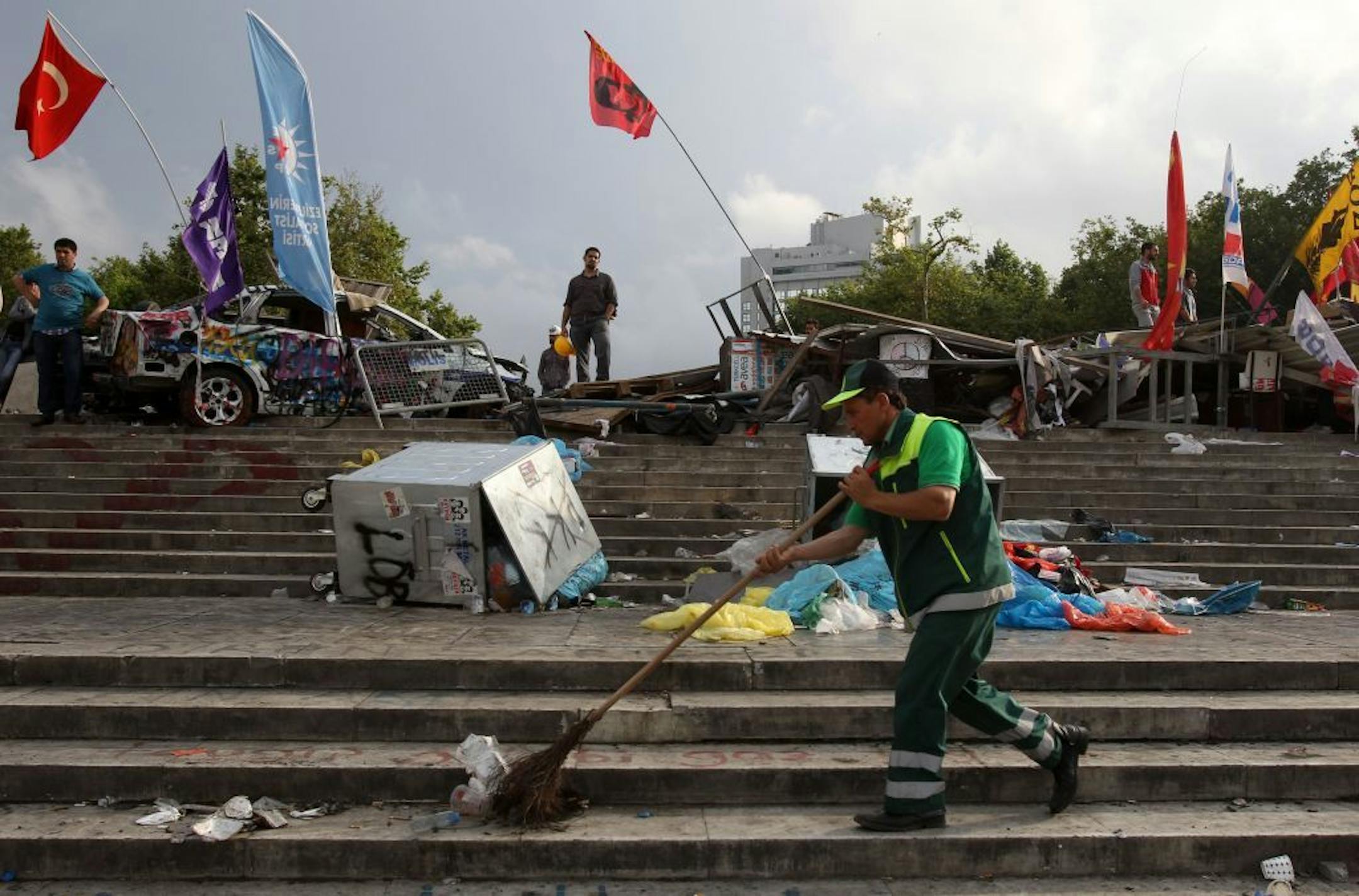 A municipality worker cleans the steps of Taksim Square under a barricade in Istanbul on Thursday, June 13, 2013.