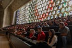 Stuents and staff listened before the stained glass windows inside the Saint John’s Abbey and University Church for the inauguration of Brian Bruess