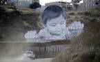 A Border Patrol vehicle drove in front of a mural in Tecate, Mexico, just beyond a barrier on the United States side. Associated Press