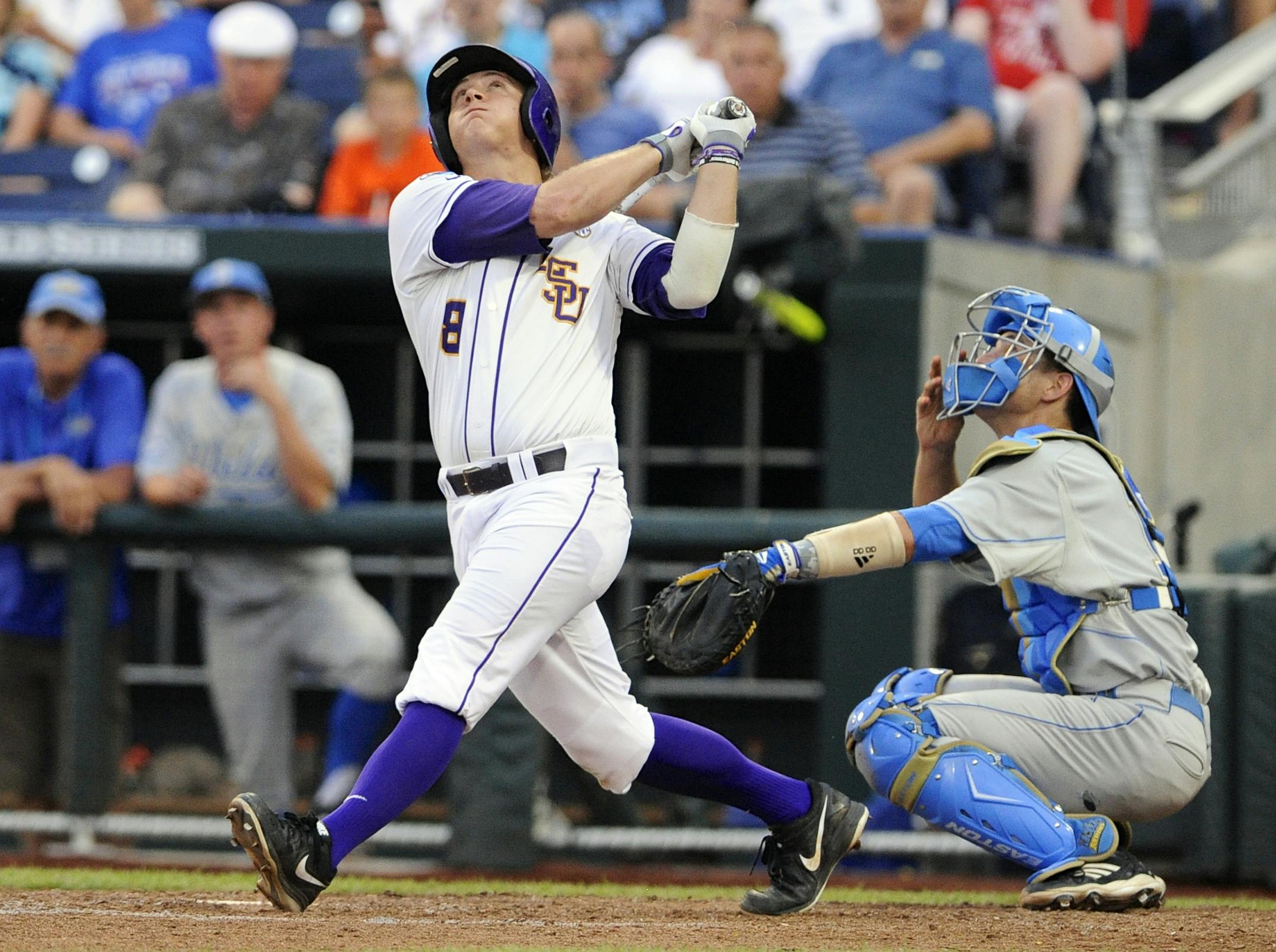 LSU's Mason Katz (8) along with UCLA catcher Shane Zeile, right, follow the trajectory of his solo home run in the fourth inning of an NCAA College World Series baseball game in Omaha, Neb., Sunday, June 16, 2013. (AP Photo/Eric Francis)