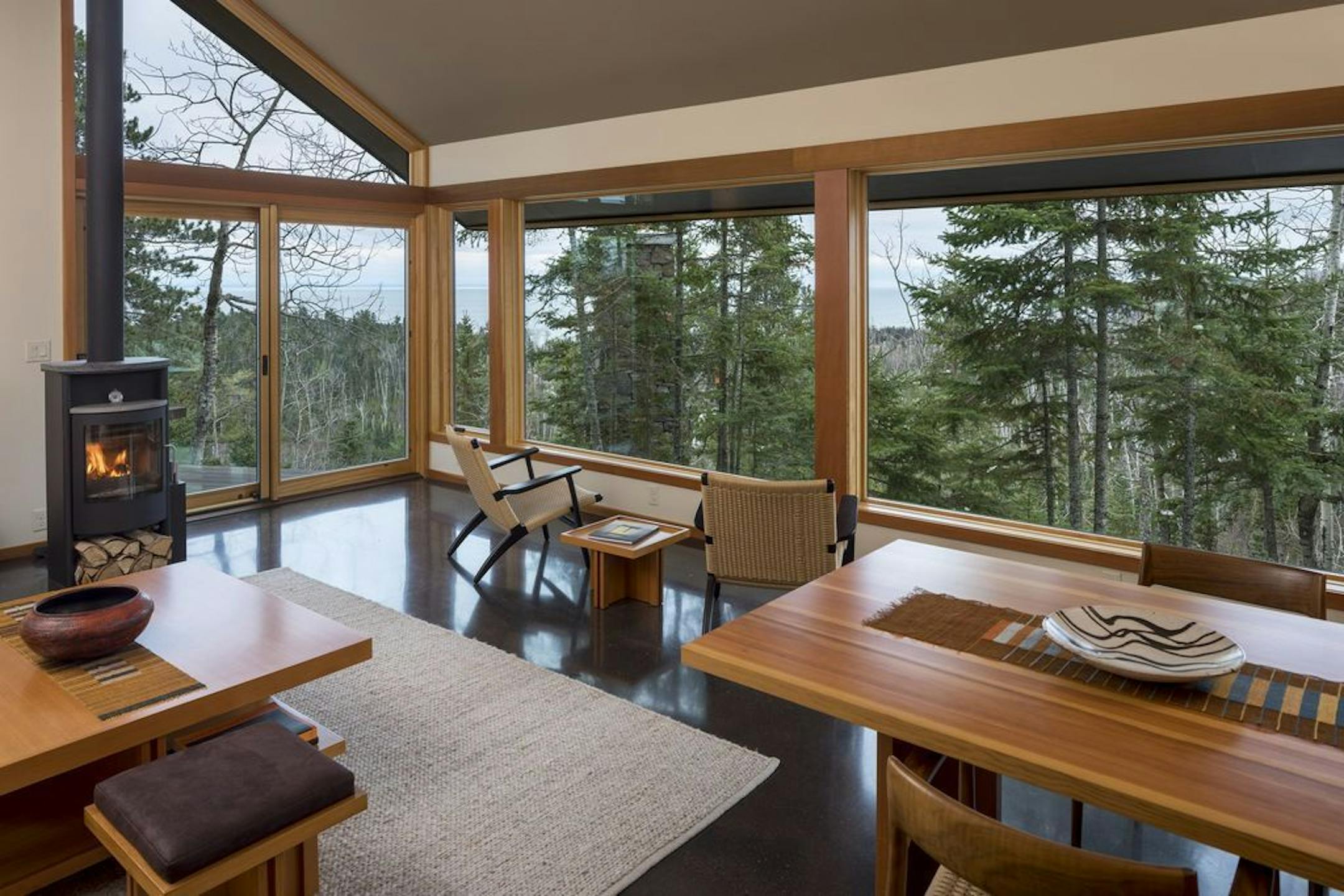 Danish Rais woodburning stove warms the living room, which is surrounded by pine trees and Lake Superior in the distance.