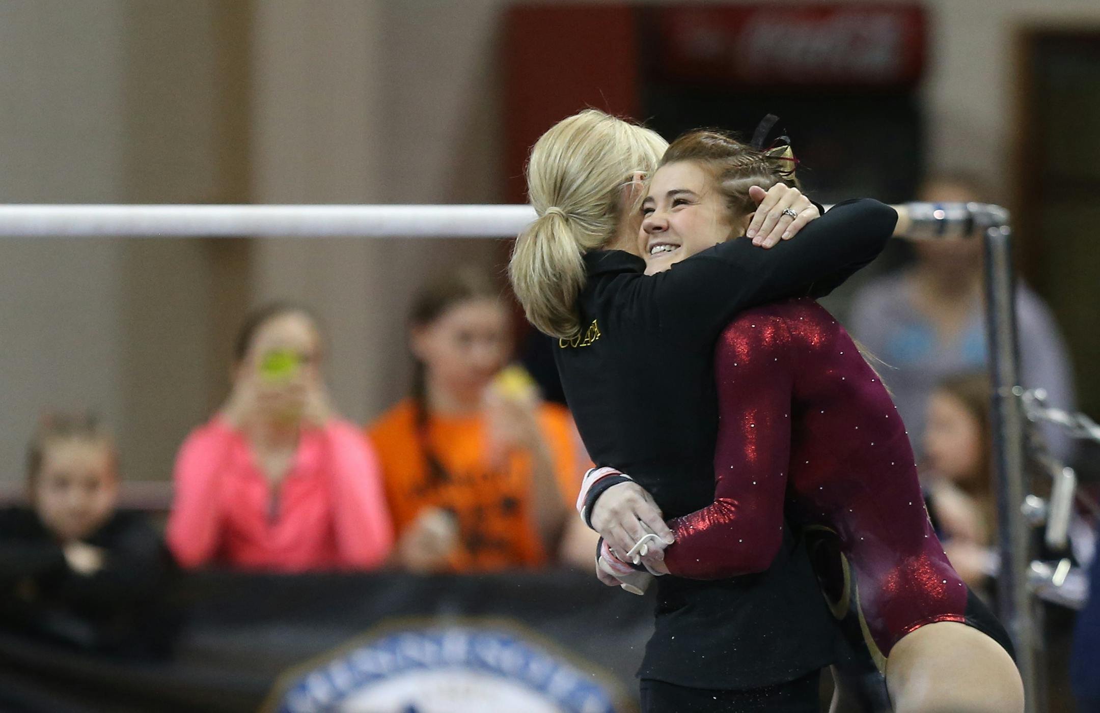 Northfield's Bailey DuPay got a hug from her coach after performing on the uneven bars during the Class 2A gymnastics state meet.