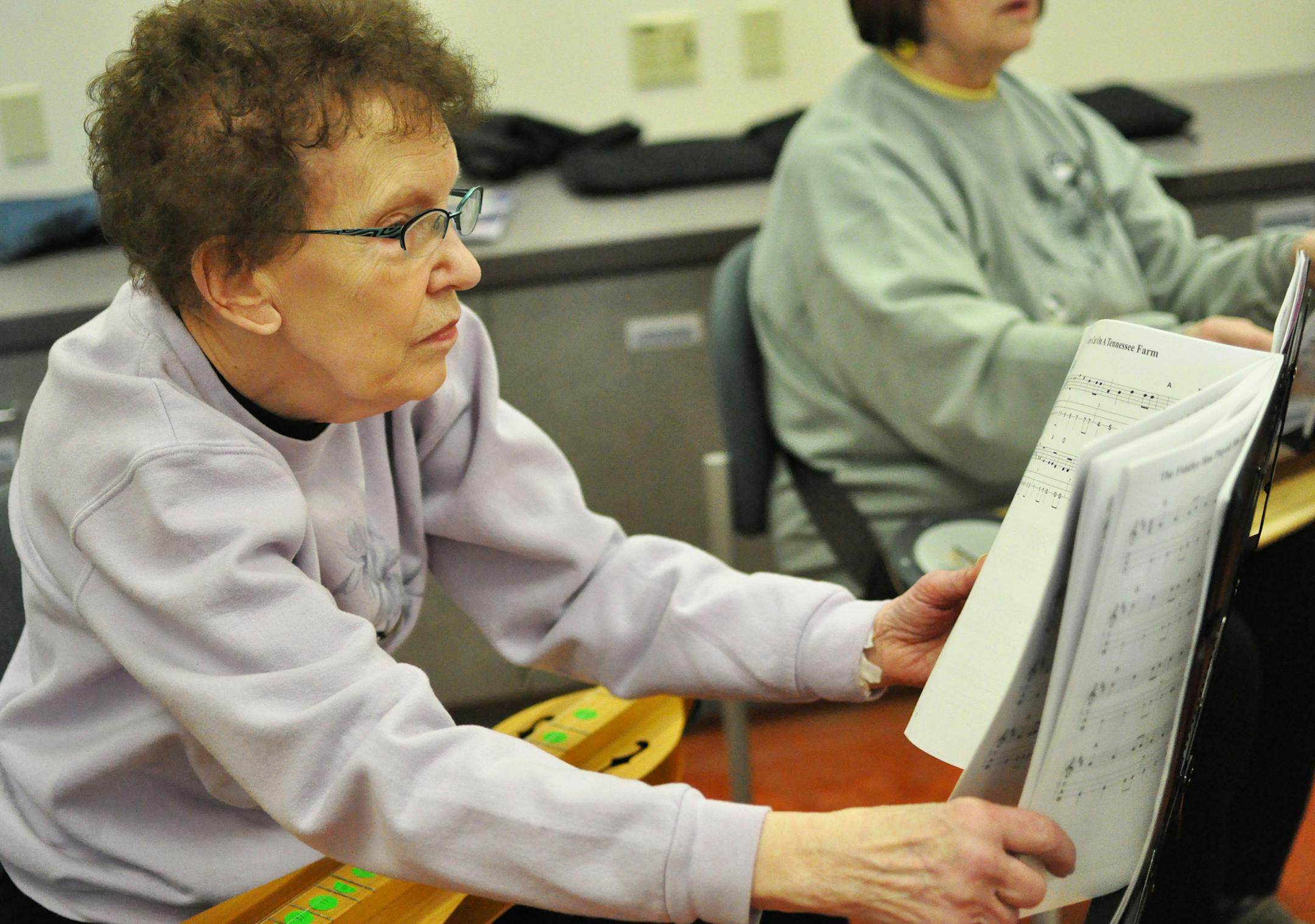 Ruth Olson, of Farmington, paged through a songbook at dulcimer club practice. Liz Rolfsmeier, Special to the Star Tribune