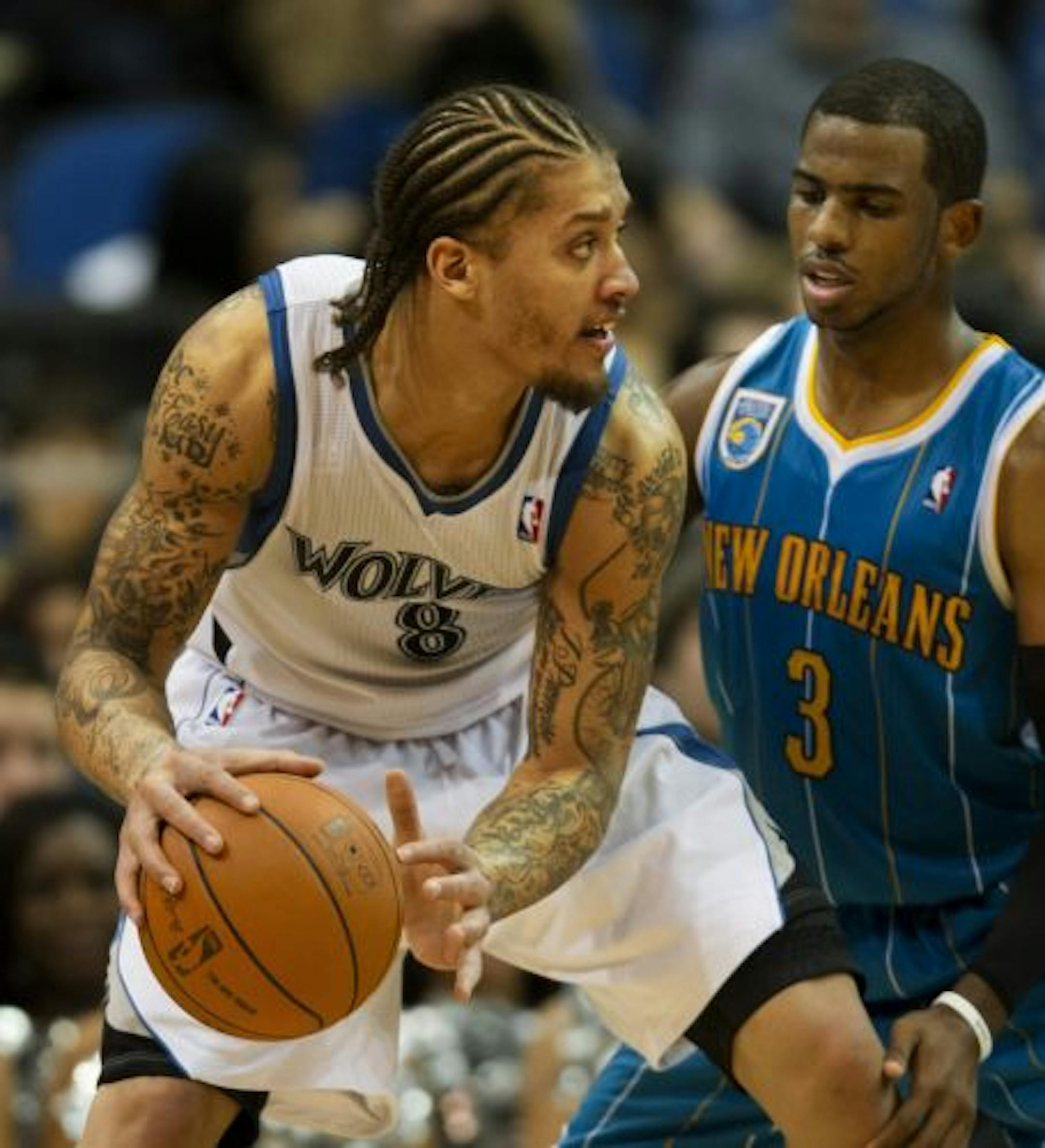 Michael Beasley keeps his eye on the basket while Hornets Chris Paul guards in the second half.