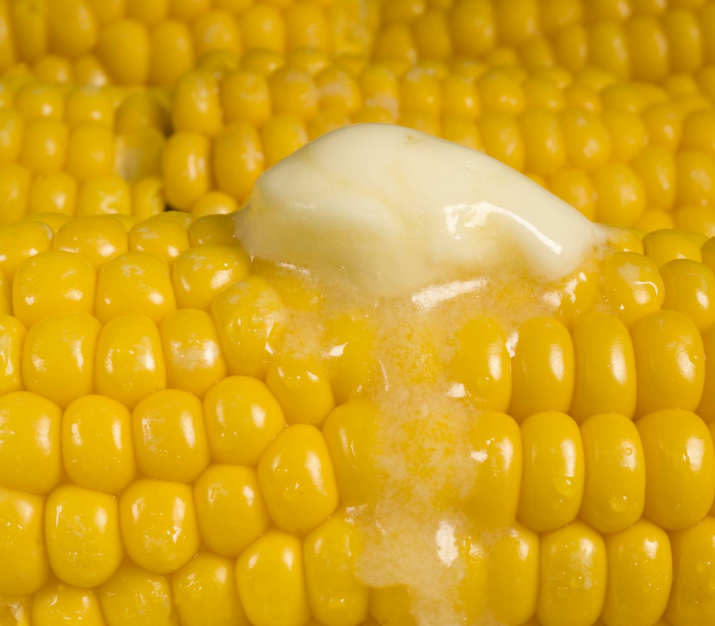 Close up of corn on the cob with melted margarine. iStock