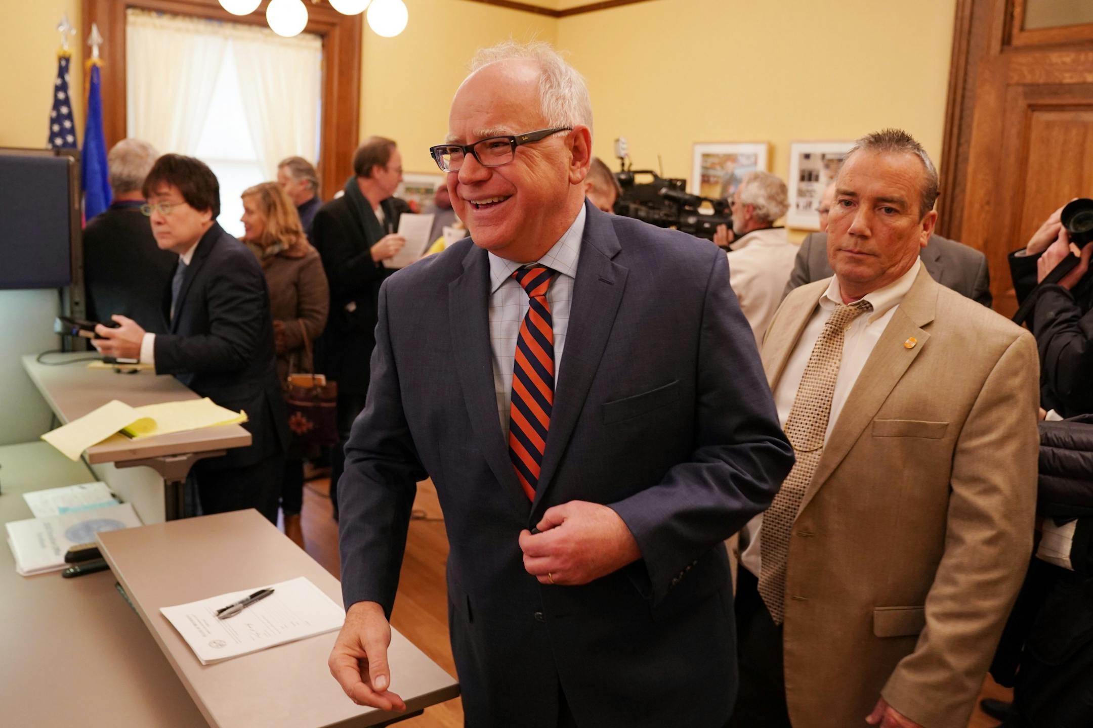 Gov.-elect Tim Walz was escorted by his protection detail away from a press conference at their transition offices in the State Capitol Thursday morning.
