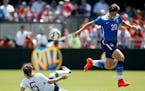 Abby Wambach, right, jumps over a tackle by Ireland's Ciana Grant (5) during the second half of an exhibition soccer match Sunday, May 10, 2015, in Sa
