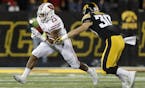 Wisconsin running back Jonathan Taylor, left, runs the ball as Iowa defensive back Jake Gervase, right, defends during the first half of an NCAA colle