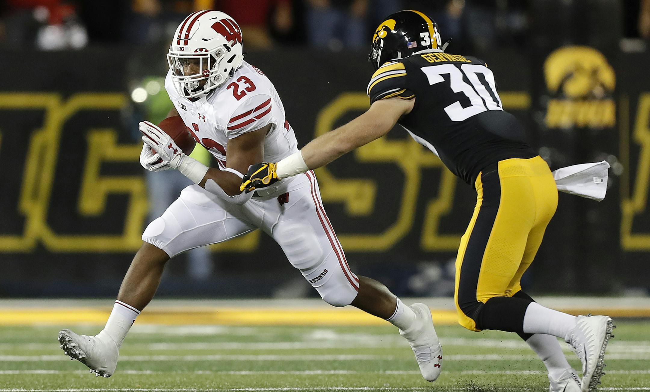 Wisconsin running back Jonathan Taylor, left, runs the ball as Iowa defensive back Jake Gervase, right, defends during the first half of an NCAA college football game, Saturday, Sept. 22, 2018, in Iowa City. (AP Photo/Matthew Putney)