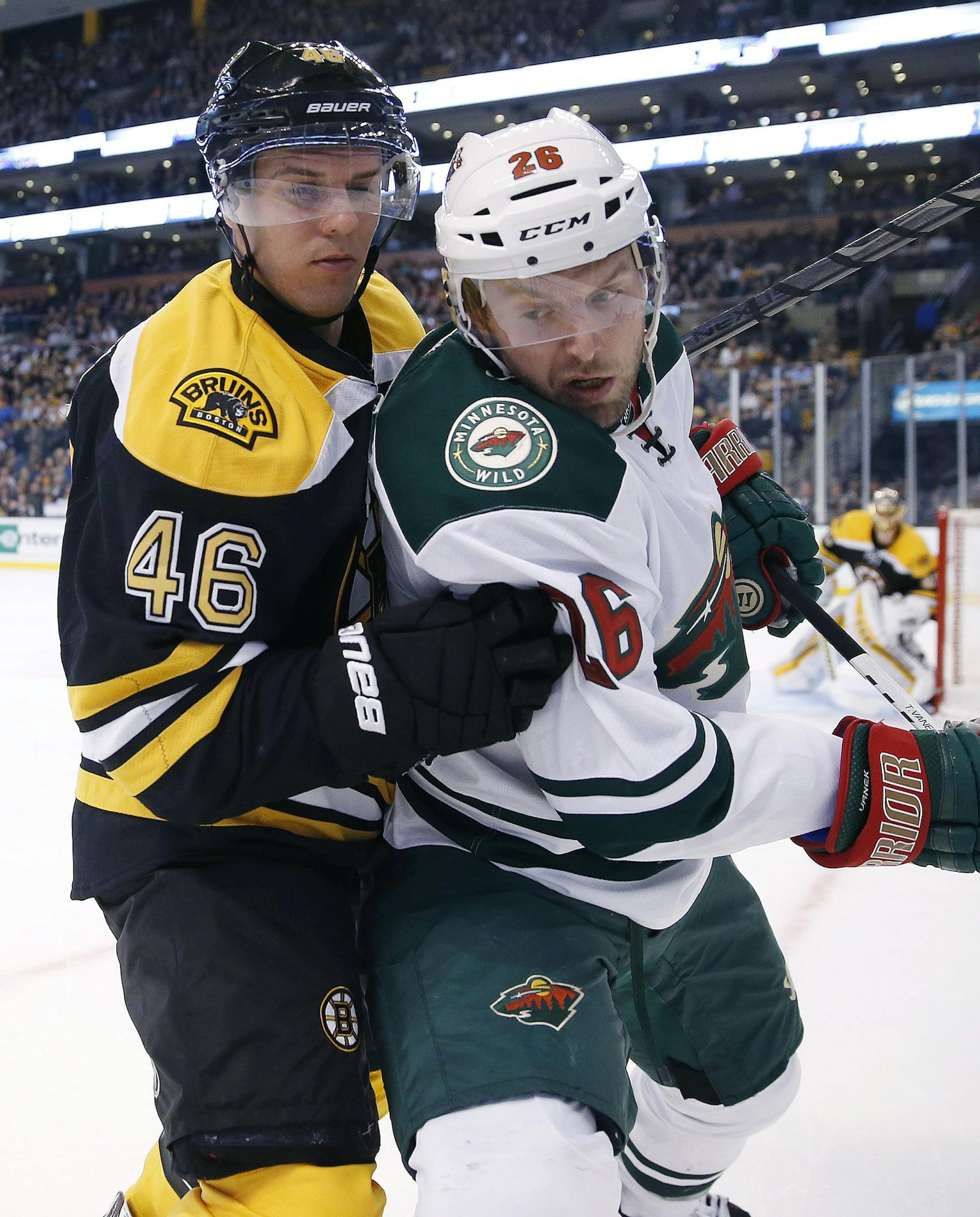 Boston Bruins' David Krejci (46), of the Czech Republic, and Minnesota Wild's Thomas Vanek (26) battle for the puck in the first period of an NHL hockey game in Boston, Tuesday, Oct. 28, 2014. (AP Photo/Michael Dwyer)
