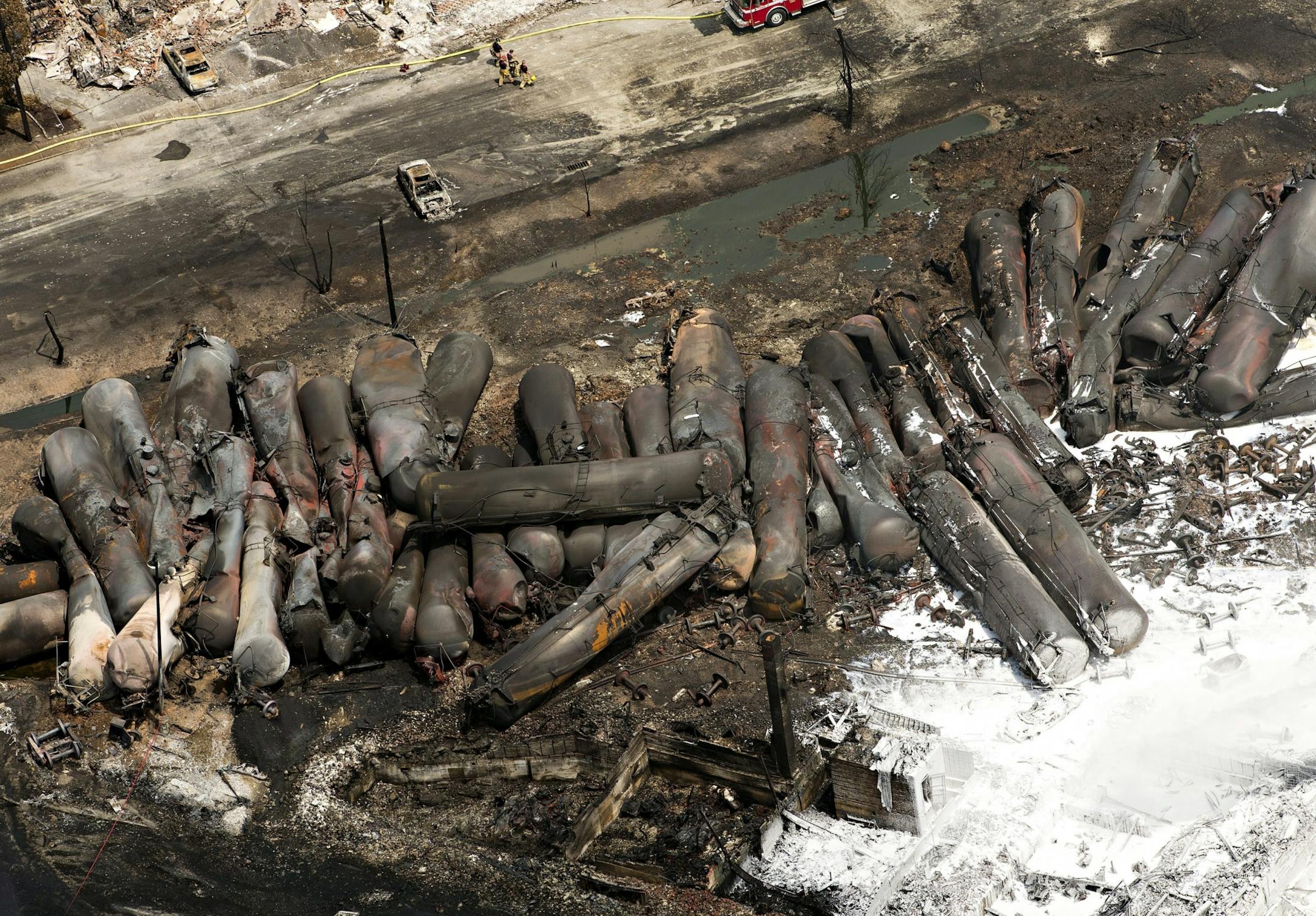 The remains of tanker cars lie burnt out in the downtown core Sunday, July 7, 2013, in Lac Megantic, Quebec. A runaway train derailed Saturday igniting tanker cars carrying crude oil and devastated the town.