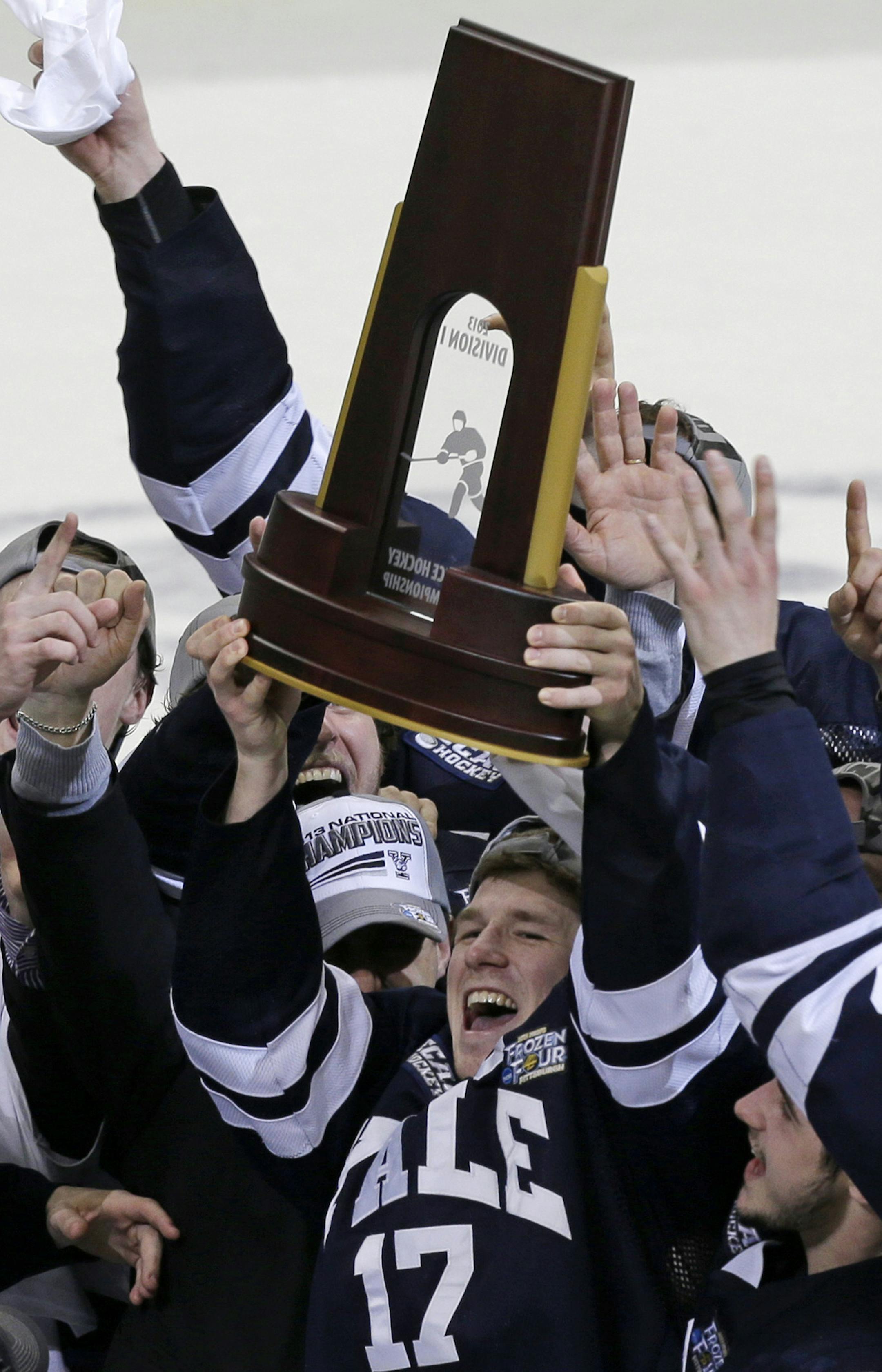 Yale captain Andrew Miller (17) hoists the trophy after Yale won the NCAA men's college hockey national championship game over Quinnipiac 4-0, in Pittsburgh Saturday, April 13, 2013. (AP Photo/Gene Puskar)