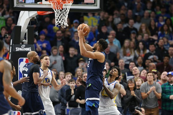 Timberwolves center Karl-Anthony Towns scored over Warriors guard Nick Young late in the fourth quarter at Target Center on Sunday.