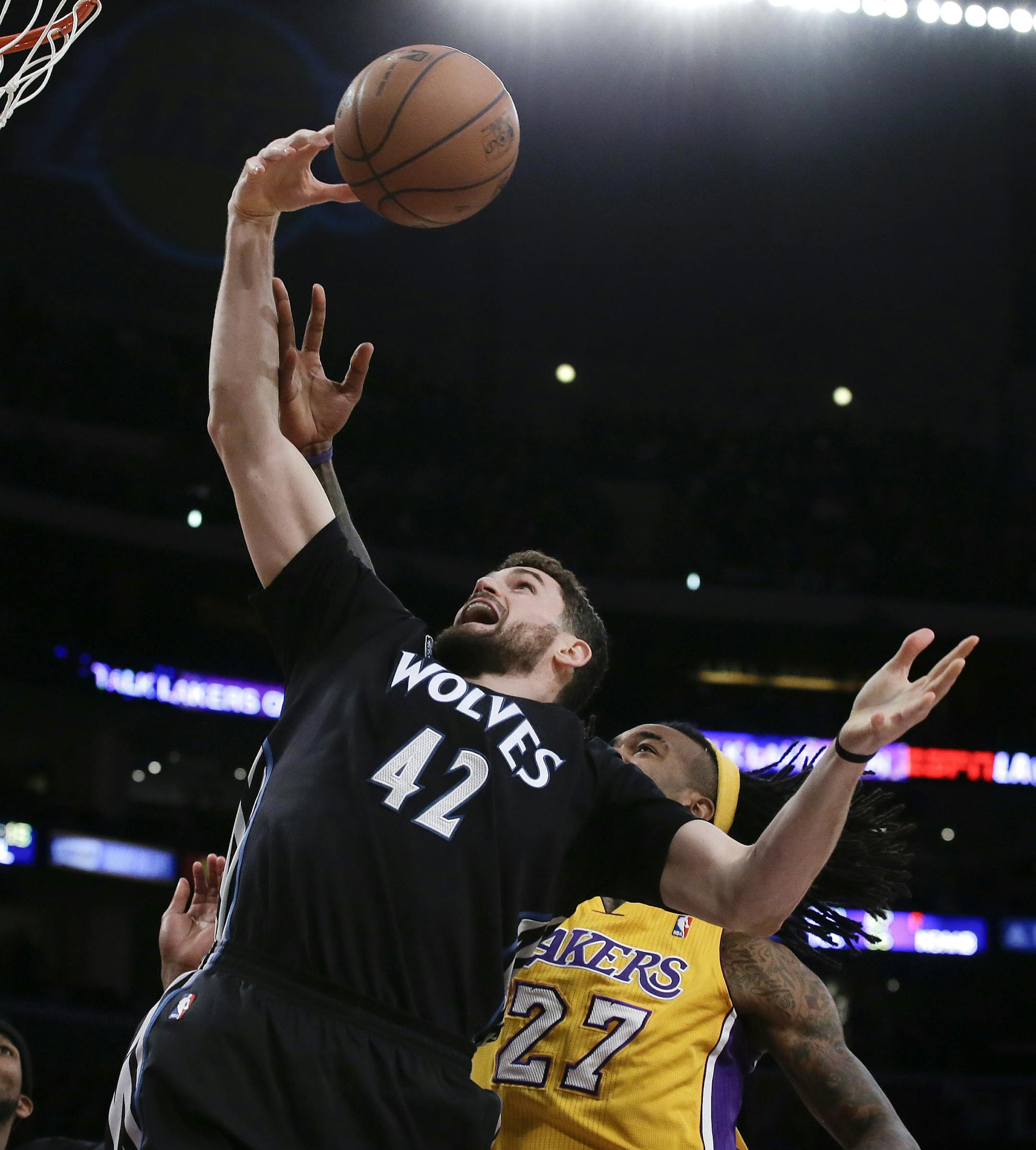 Minnesota Timberwolves forward Kevin Love pulls a rebound away from Los Angeles Lakers center Jordan Hill during the first half of an NBA basketball game in Los Angeles, Friday, Dec. 20, 2013. (AP Photo/Chris Carlson)