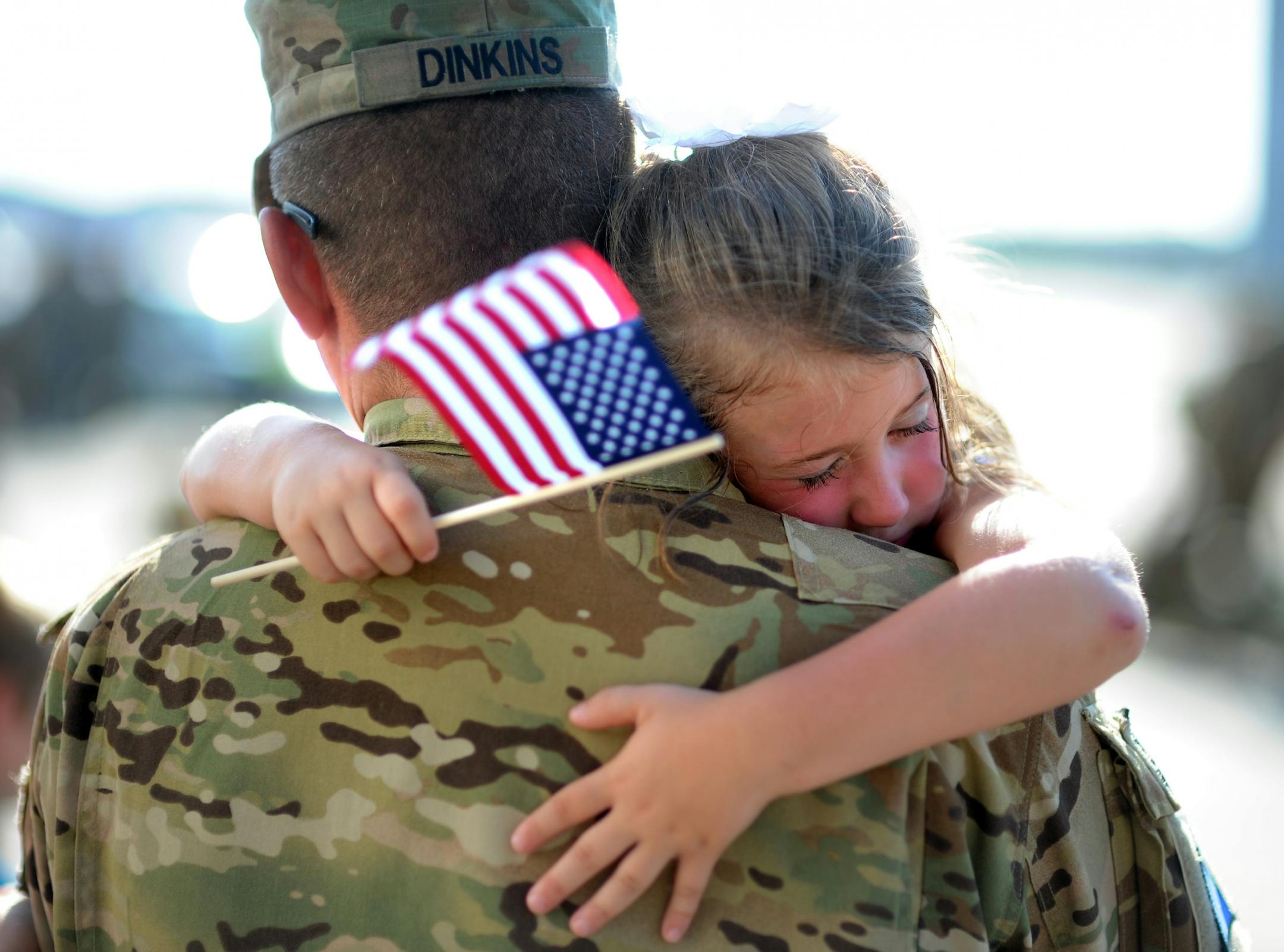 U.S. Army Staff Sgt. Jason Dinkins with the 3rd Combat Aviation Brigade is hugged by his daughter Olivia Chastain after a welcome home ceremony, Tuesday, June 11, 2013 at Hunter Army Airfield in Savannah, Ga. The aviation brigade deployed 2,200 soldiers to Afghanistan in December on a 9-month mission, but came home earlier than expected because of the readiness of the Afghan National Security.