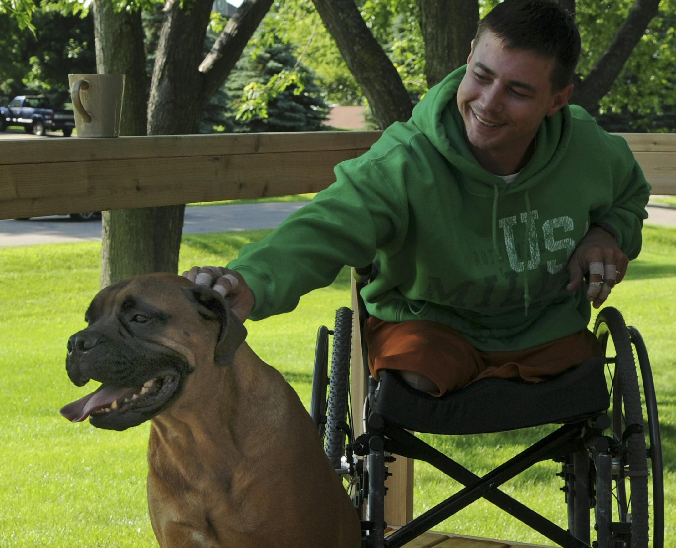 Staff Sgt. Kyle Malin, 28, returned home to Lakeville this week from months of surgery and rehab after he stepped on a land mine in Afghanistan and lost both legs. Kyle reached out to pat his dog Hooch on the front porch.