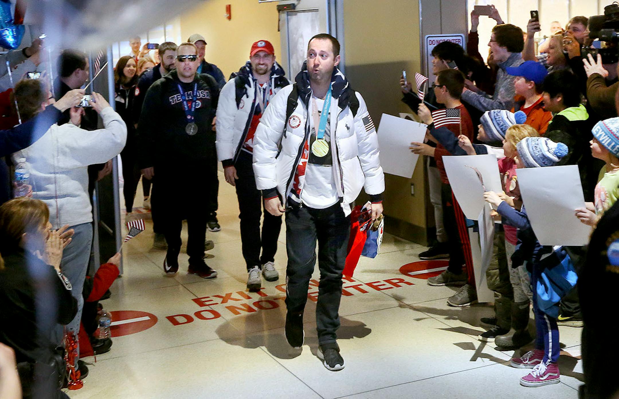Duluth curling team member Tyler George can't believe his eyes at the crowd that turned out to welcome the team home Monday at the Duluth International Airport. George is followed by the other members of the team as they first make their way into the terminal after landing. Bob King / rking@duluthnews.com