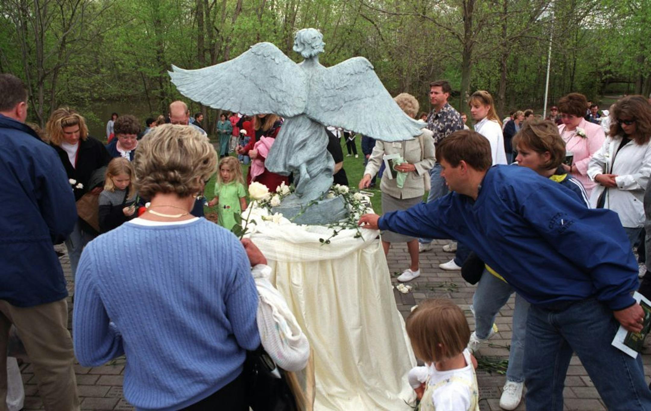 MAPLE GROVE, MN, 5/6/01, SUNDAY- About 500 people gathered at the Maple Grove Arboretum Park to dedicate The Angel of Hope for families grieving the loss of a child of any age. After the dedication of the monument, parents, family and fiends placed flowers for their loved ones around the angel. Each year in the U.S., out of an estimated 4.4 million confirmed pregnancies, there are more than half a million miscarriages, 29,000 stillbirths and 39,000 infant deaths under one year of age.