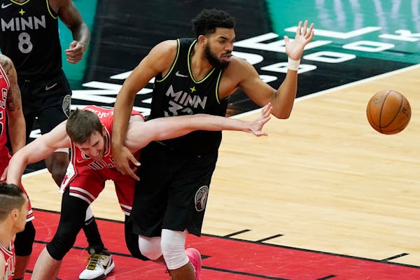 Chicago Bulls forward Luke Kornet, left, and Timberwolves center Karl-Anthony Towns battle for a loose ball during the first half
