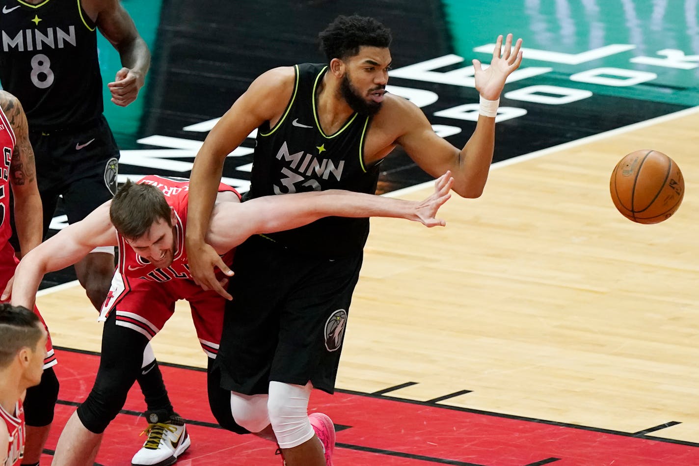 Chicago Bulls forward Luke Kornet, left, and Timberwolves center Karl-Anthony Towns battle for a loose ball during the first half